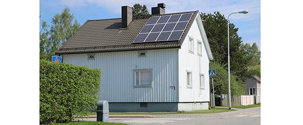 Vit villa med solceller monterade på taket.