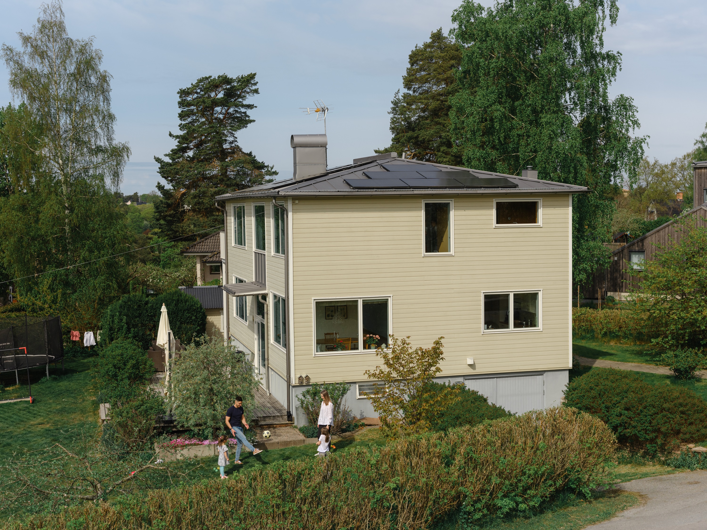 Familj utanför sin villa med solceller